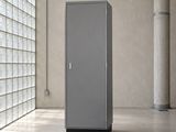 une grande armoire métallique dans une pièce dont l'un des murs est constitué de briques de verre
