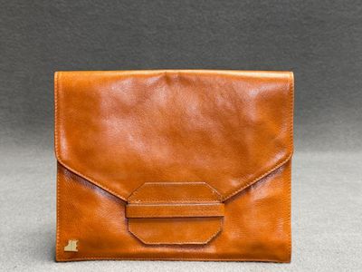 Jacques Esterel à Paris. Pochette en cuir cognac.