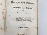 an old book that is open on a white surface