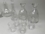 a lot of empty glass bottles and glasses on the table