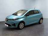 La voiture bleue est garée dans une pièce aux murs blancs.