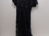 a black dress hanging on a hanger in front of a white wall
