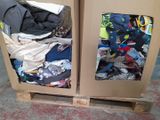 two cardboard boxes with clothes on top of them on a pallet