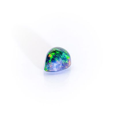 a close up of a green and blue oplite stone on a white surface