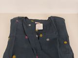 the shirt is blue with polka dots on it and has a small yellow dot on it