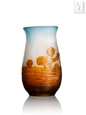 un vase en verre avec un tableau posé sur une table