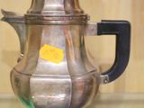 une théière en argent posée sur une table en verre