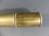 a small brass object on a white surface