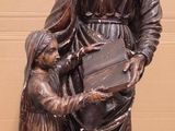 statue en bronze représentant une femme tenant un enfant et un livre