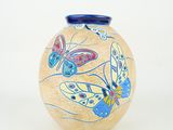a vase with a butterfly design on it on a white background
