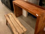 un banc en bois placé à côté d'une table en bois dans une pièce