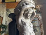 a statue of a woman holding a basket on her head