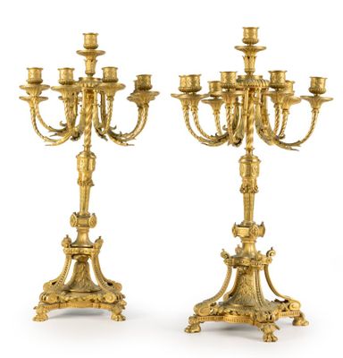 paire de chandeliers anciens en laiton avec des bougies posées sur des socles