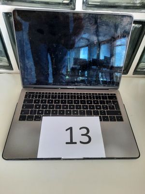 un ordinateur portable posé sur une table sur laquelle figure le chiffre 13