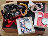 a box with a watch, bracelets, and other items in it