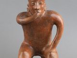 une petite figurine représentant un homme coiffé d'un chapeau
