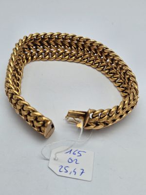 a close up of a gold bracelet with a tag on it