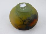 un vase vert et jaune posé sur une surface blanche