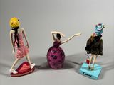 three figurines of a woman on a skateboard and a man on a skateboard
