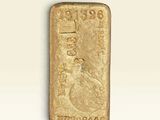 un lingot d'or posé sur une surface blanche, sur fond blanc