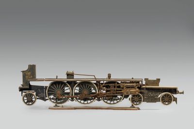 une vieille maquette de locomotive à vapeur posée sur une surface blanche