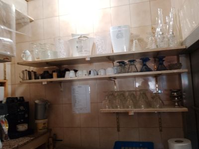 de nombreuses tasses et verres sur les étagères de la cuisine