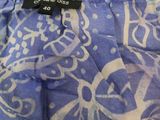 the bottom of a blue and white patterned bag with a black tag on it