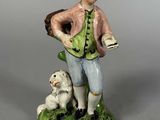 figurine représentant un homme avec un chien sur un fond vert