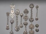 plusieurs bijoux en argent posés sur une surface grise