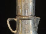 une cafetière en argent et une théière en argent sur fond noir