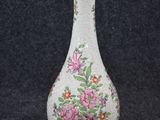 un vase blanc orné de fleurs roses sur fond noir