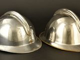 two silver hard hats sitting on top of each other