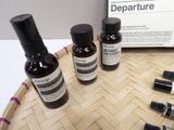 three bottles of departure sitting on top of a wooden tray