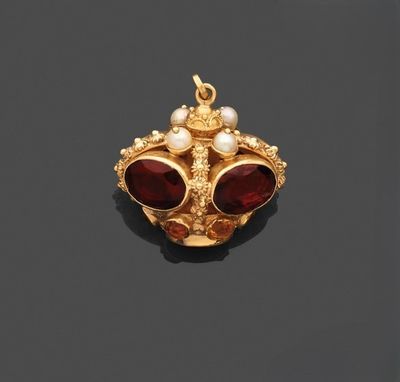 un pendentif en or orné de grenats et de perles sur un fond noir