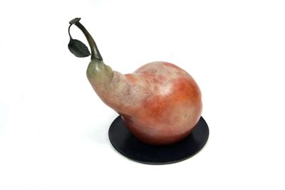 a figurine of a pear on a black plate
