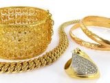 deux bagues en or, un bracelet et une bague sur fond blanc