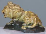 statue of a lion on a rock with its mouth open