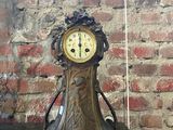 une horloge posée sur une table devant un mur de briques
