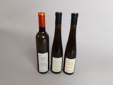 trois bouteilles de vin posées l'une à côté de l'autre sur une table
