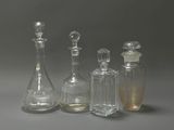 three clear glass bottles sitting next to each other on a gray surface