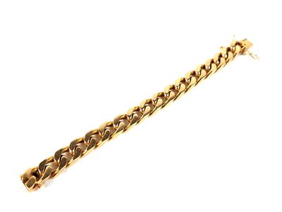 gros plan d'un bracelet en chaîne en or sur fond blanc