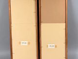 two wooden boxes with labels on them sit side by side on a gray surface