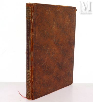 an old book sitting on top of a white table next to a white wall