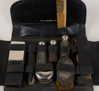 a black case with a brush, comb, and other items in it