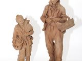 trois figurines en argile représentant un homme et une femme debout l'un à côté de l'autre