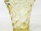 un vase en verre jaune posé sur une table
