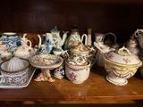many different types of pottery on a wooden shelf