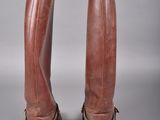 pair of brown leather boots with gold buckles on the toes