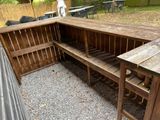 a wooden outdoor kitchen with a grill and a table