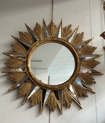 un miroir doré en forme d'étoile accroché au mur
